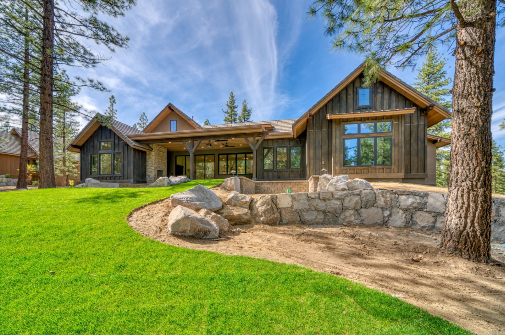 Rear elevation with pocketing glass doors and manicured lawn