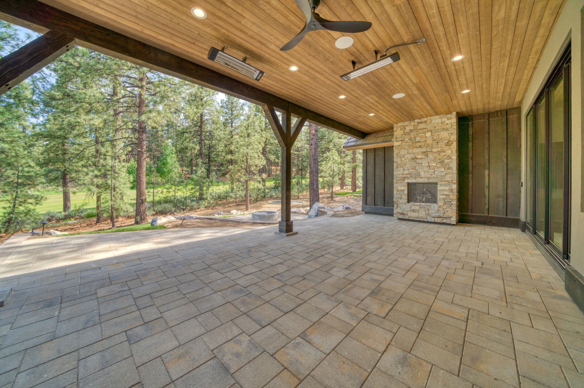 Covered loggia with outdoor fireplace overlooking the pines