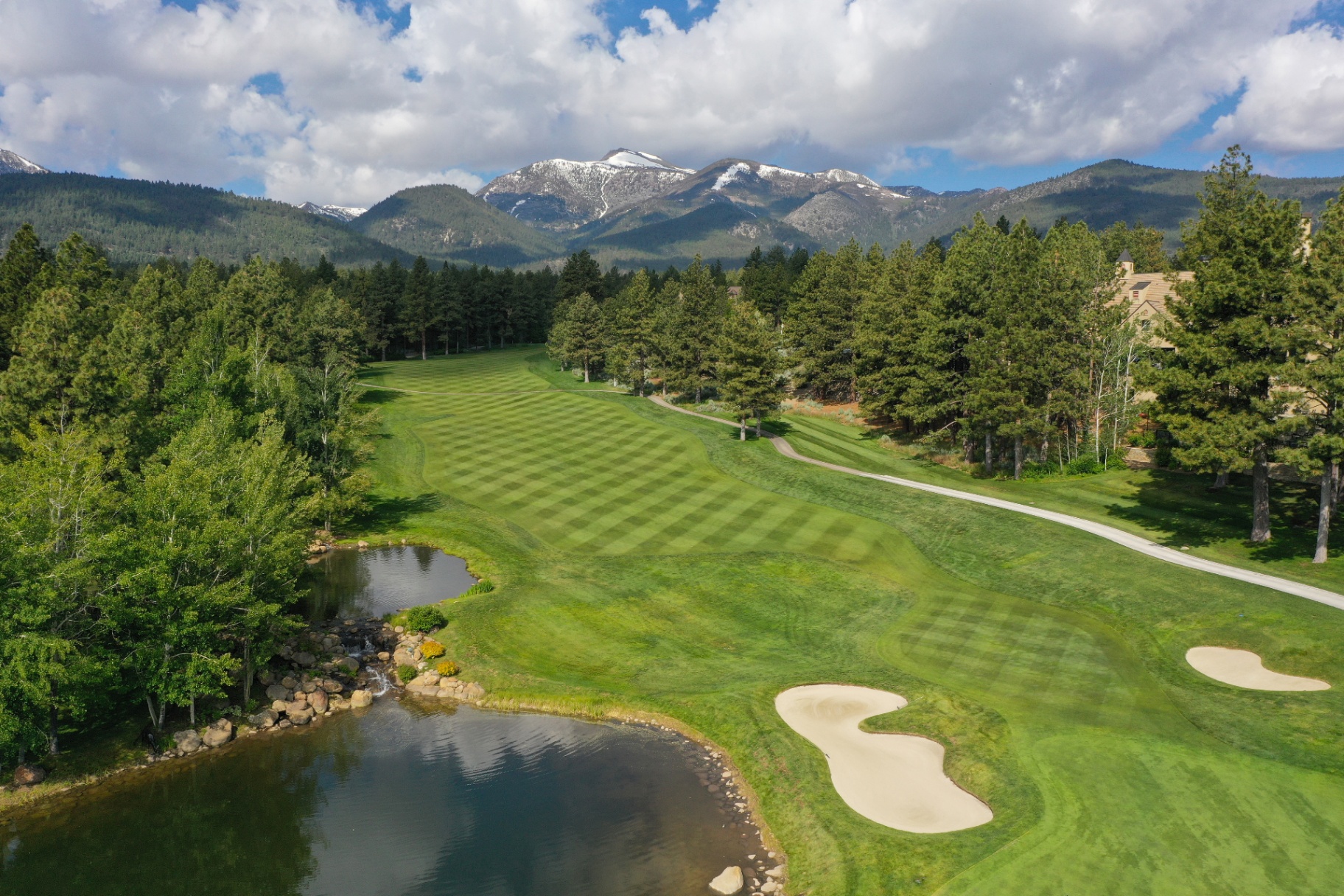 Jack Nicklaus Signature golf course fairway winding through Montreux with snow-capped Sierra Nevada peaks beyond