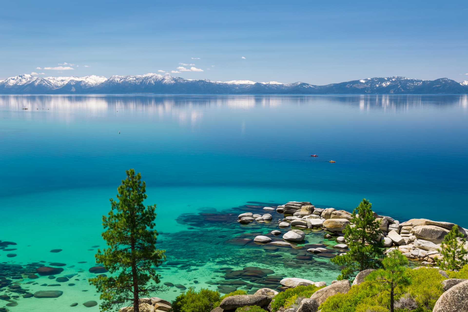 Crystal-clear turquoise water of Lake Tahoe framed by pines and granite boulders