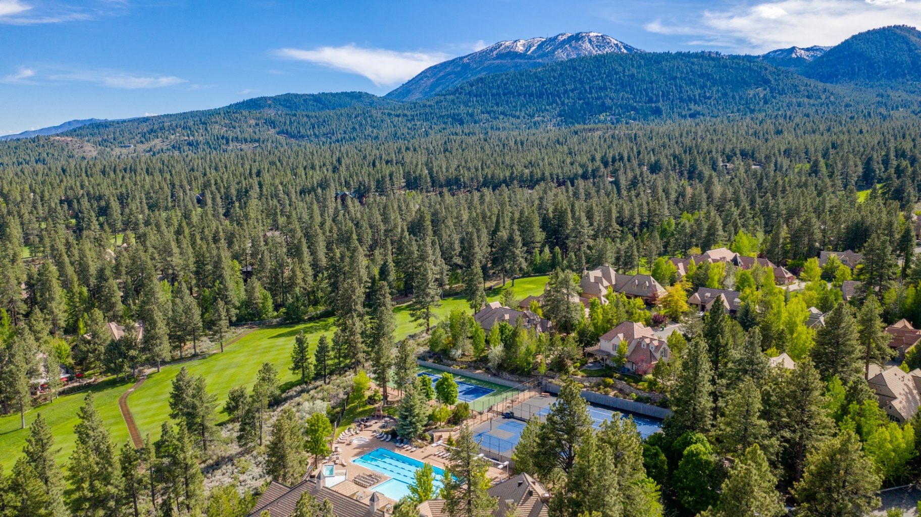 Montreux community pool and tennis courts surrounded by pine forest with the Sierra Nevada in the background