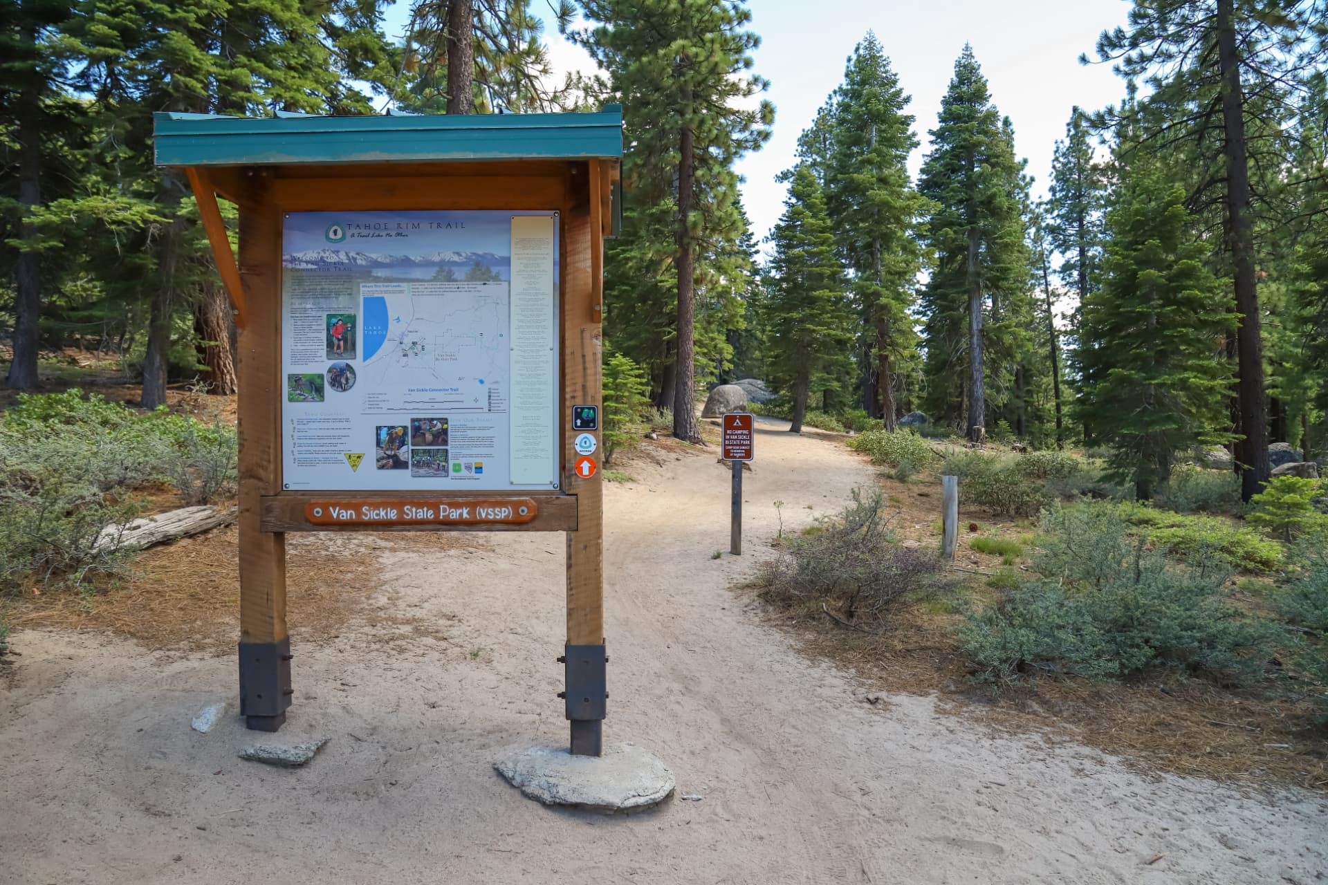 Tahoe Rim Trail trailhead kiosk in a sunlit pine forest at Van Sickle State Park